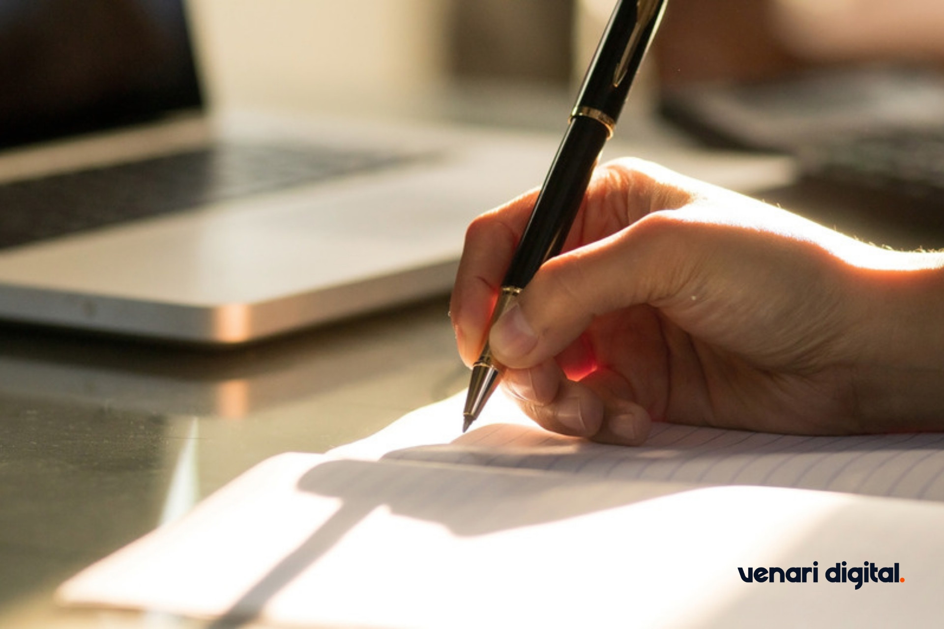 Hand writing notes in a notebook in natural light
